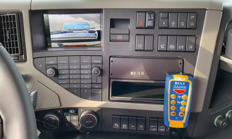 Fahrerhaus mit Bär SmartControl CabinControl und Splitscreen-Ansicht der blau beschichteten Bär Plattform am Monitor